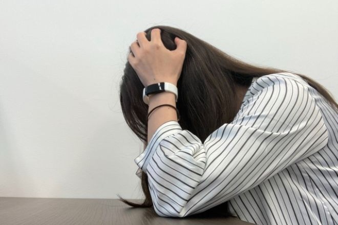 頭を抱える女性。親友から突然縁を切られた過去――時間が経った今、彼女の真意を知りたい|30代女性からの調査相談。